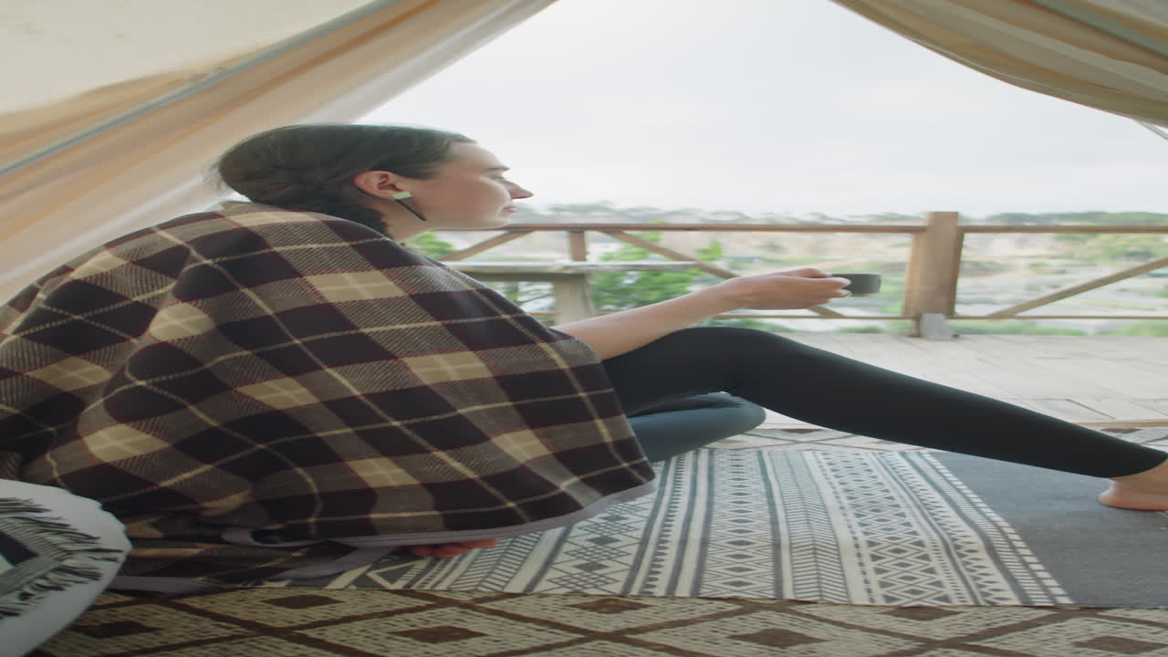 Woman Sitting in Glamping Tent, Drinking Tea and Enjoying View