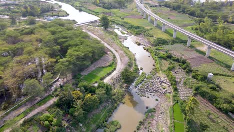 Vista-Aérea-De-Volar-Sobre-El-Ferrocarril-Cerca-De-Un-Río