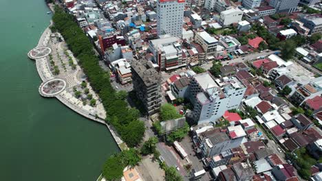 Drone-Volando-Sobre-La-Ciudad-De-Makassar-Sulawesi-Indonesia-Durante-Un-Día-Soleado-Con-Tráfico-Y-Edificios-Debajo-A-Lo-Largo-De-Un-Río