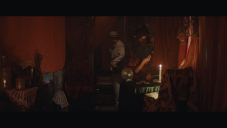 a man in hat checks the inside of the gypsy circus cart