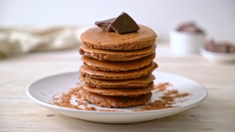 pila de panqueques de chocolate con chocolate en polvo