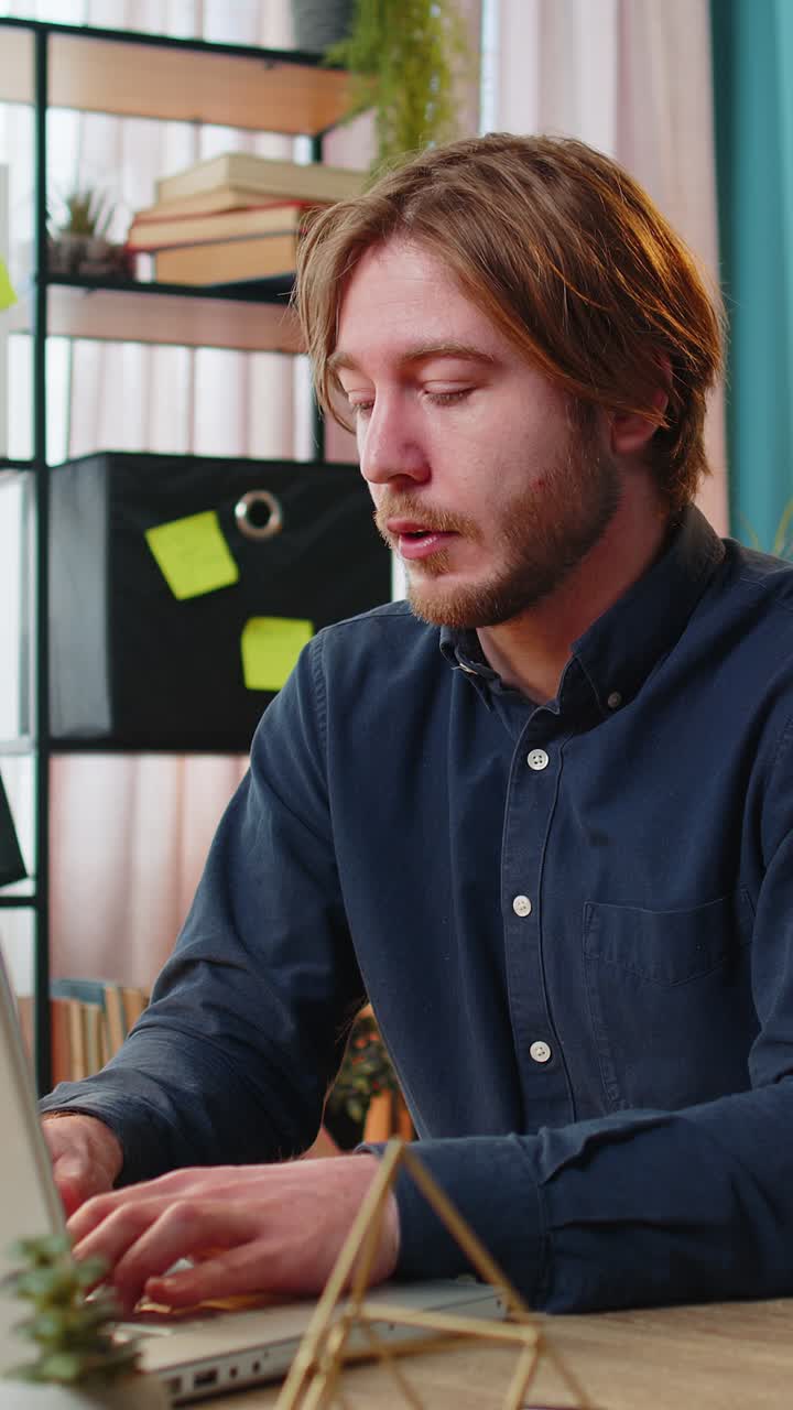 Bored sleepy businessman worker working on laptop rubbing eye pinch nose pain headache at office