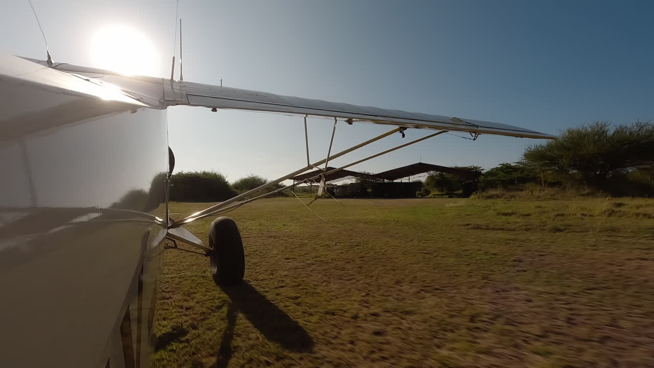 Piccolo aereo di profilo che rulla su una pista erbosa