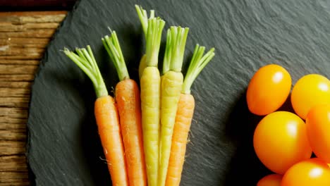 Tomatoes-and-carrots-arranged-on-wooden-table-4k