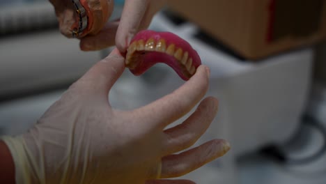 close up of hygienist pointing gum of denture showing how realistic it is