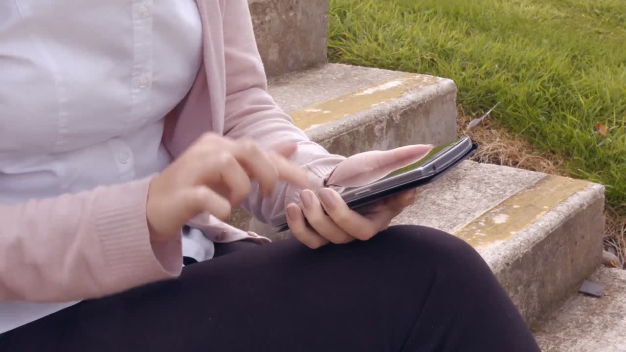 아시아 사업가 여성 이 밖 에서 전화 를 사용 하고 있다