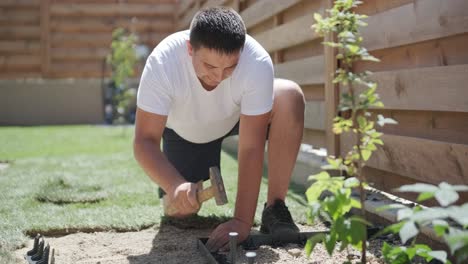 gardener laying a roll of natural lawn turf