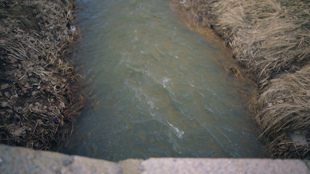 야외 하수구에서 흐르는 물 위에서 천천히 밀어넣는 샷