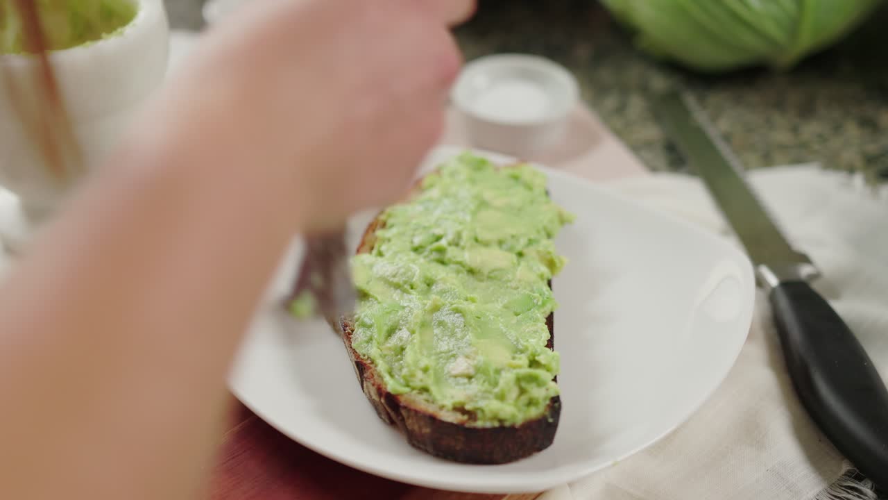 Toast con avocado servito su un piatto bianco con uno sfondo rustico, semplice e fresco
