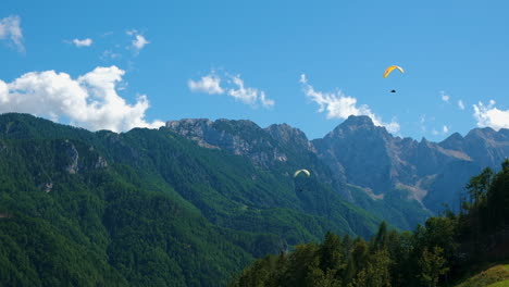 flying in the mountains, paraglider in alpine landscape, freedom and adventure concept, adrenaline sport, logar valley in slovenia