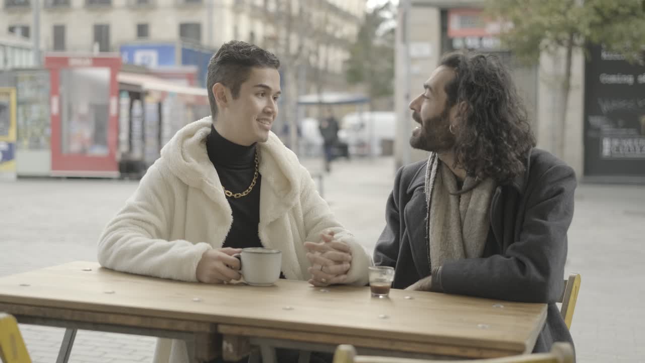 Two men enjoying coffee and conversation at an outdoor cafe