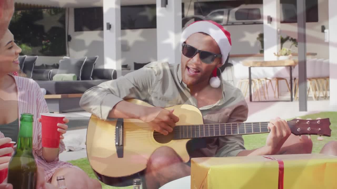 Animazione di una bandiera americana che sventola sopra un gruppo eterogeneo di amici che bevono birra con la chitarra al sole a Natale.