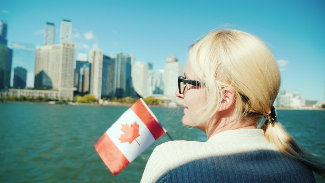 Mujer sostiene bandera canadiense junto al horizonte de Toronto