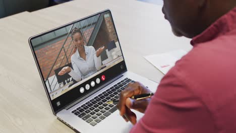 African-american-man-using-laptop-for-video-call,-with-business-colleague-on-screen