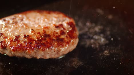 frying the meat burger with a spatula on the pan.