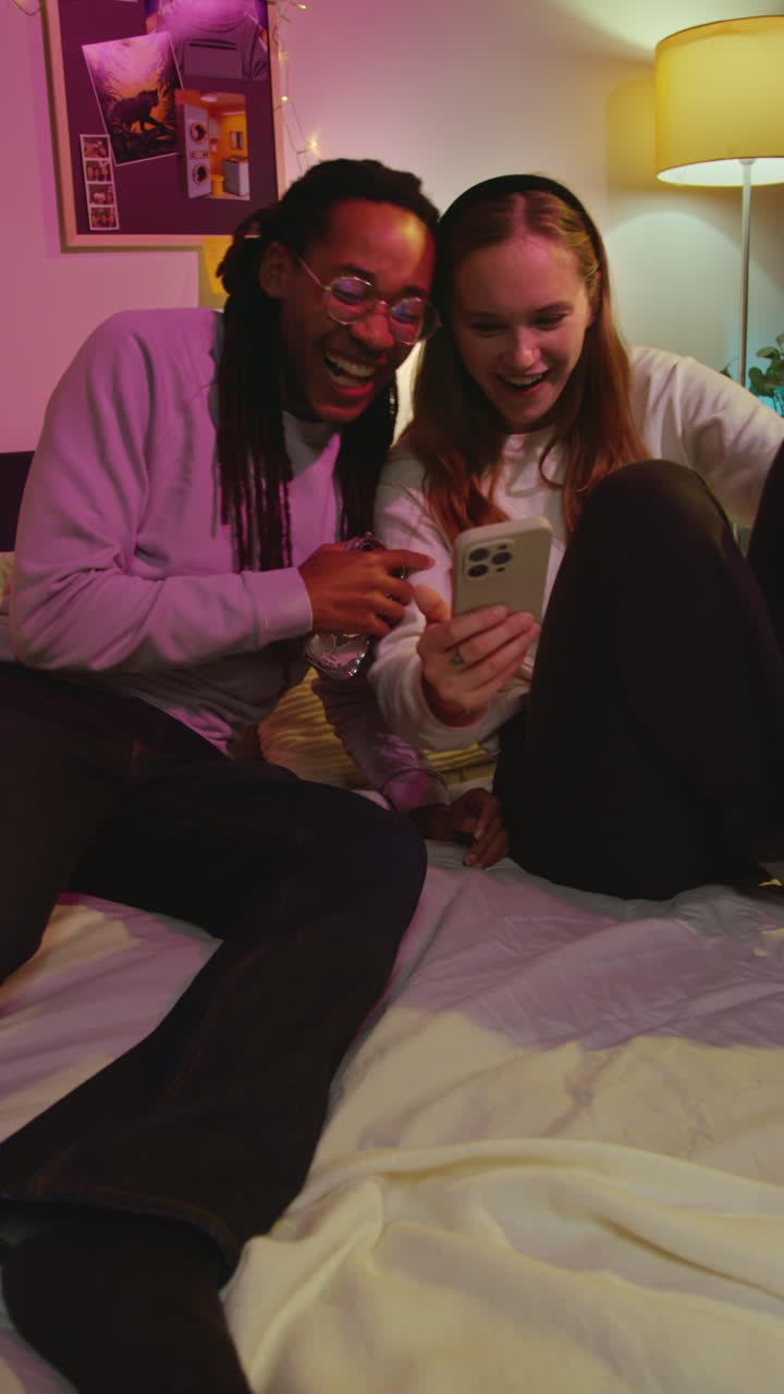 Par griner og kigger sammen på en telefon
