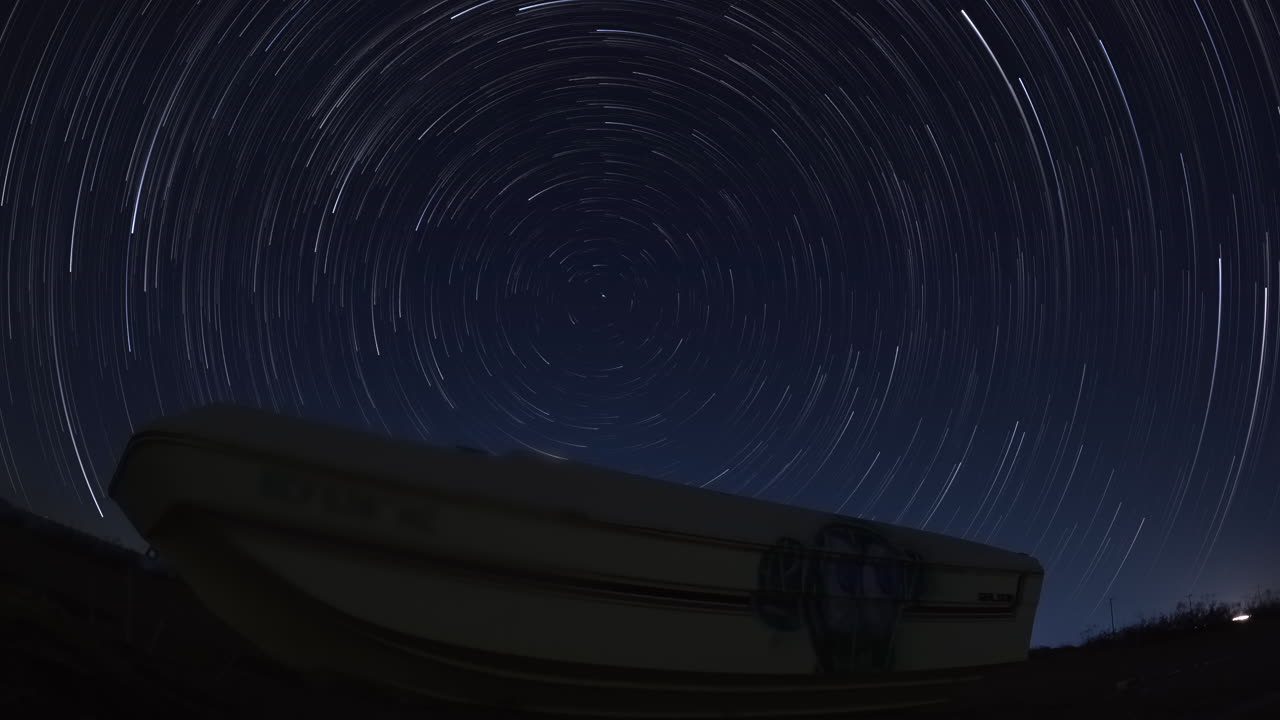 폴라리스 스타 트레일 시간 경과의 전경에 있는 모하비 사막의 도로 옆에 버려진 오래된 버려진 보트