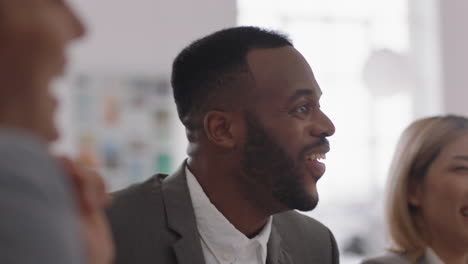 happy african american businessman celebrating success with colleagues dancing having fun enjoying teamwork in boardroom meeting