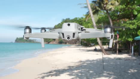 drone flotando en una playa con selva y océano en segundo plano