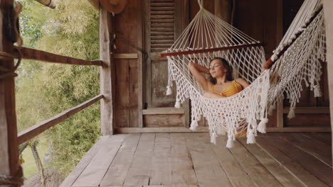 sexy woman in hammock enjoying comfortable lifestyle on vacation in holiday resort swaying peacefully on lazy summer day in tropical paradise cabin