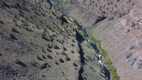 Deschutes-River-in-high-desert-canyon-rising-into-shot-of-Cascade-Mountains