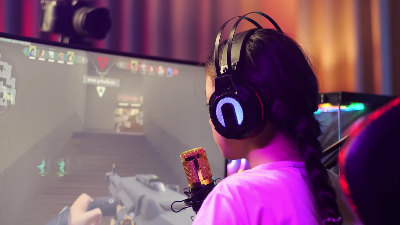 vista de atrás de cerca de la chica asiática streamer gritando gol celebrando el juego ganador a través de la red en la computadora personal. videojuego de transmisión en vivo, escritorio iluminado por luz de tira de led rgb