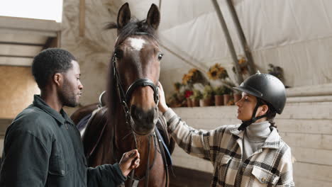 young woman petting a brown horse