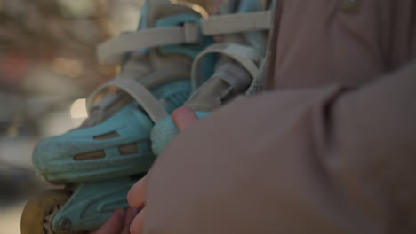 toma de primer plano centrada en una chica que sostiene una patineta, con una chaqueta de melocotón, con su cabello largo parcialmente visible. textura y detalle de la patineta y la chaqueta, con un fondo suave y borroso