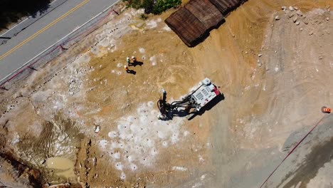 a drilling machine bores holes into the ground for explosives