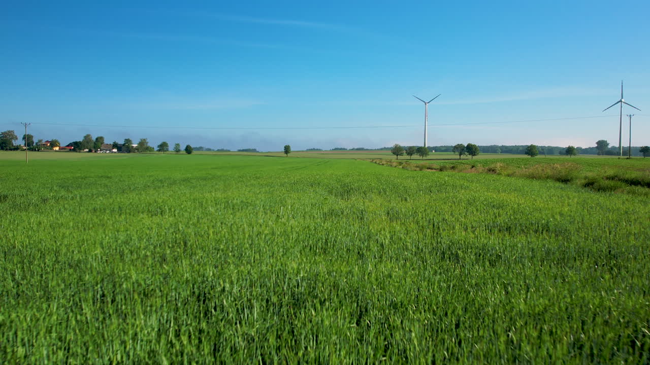 Green Fields With Wind Turbines In Background - aerial pullback
