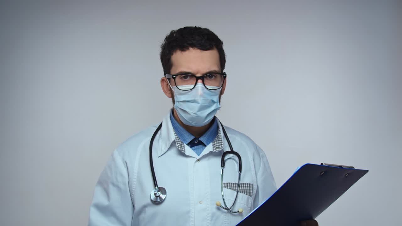 Doctor says NO, disagreement, stop. Frightened worried man doctor on white background looking at camera and starts waving his hands nervously, shouting no-no-no