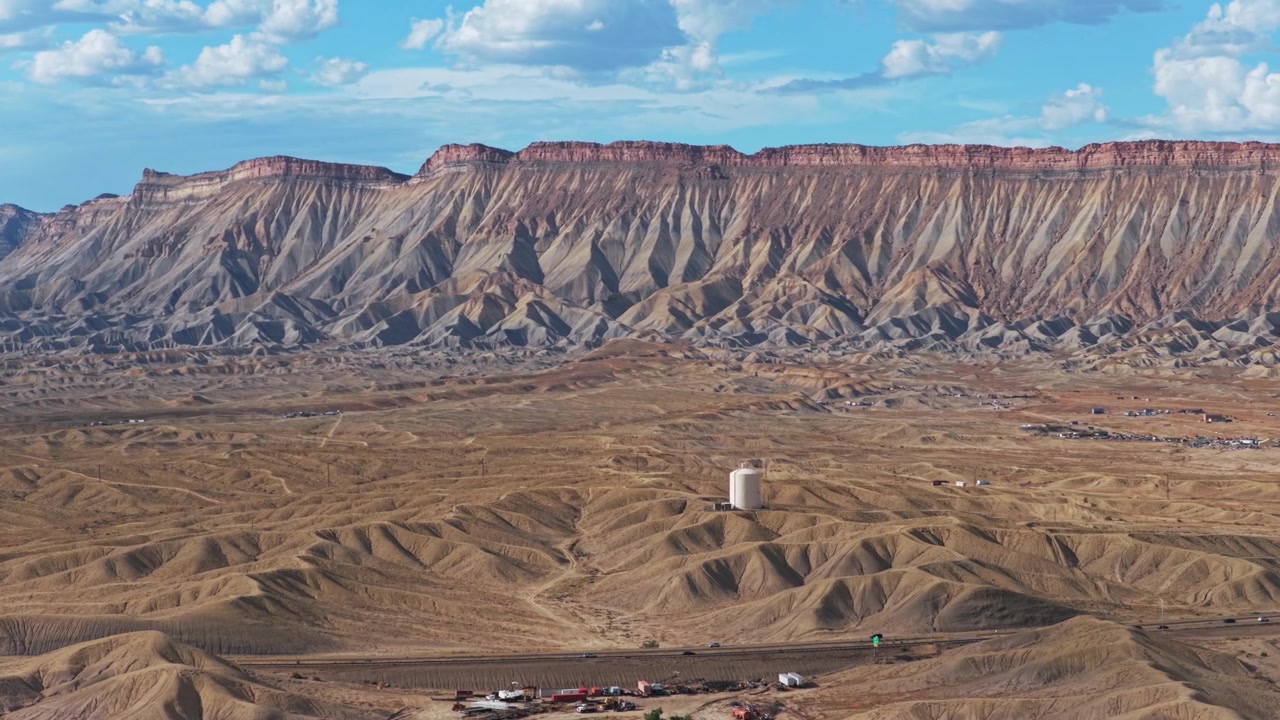 Aerial drone view of Colorado River cars i70 Book Cliffs Mesa Clifton Downtown Grand Junction tower Colorado afternoon clouds summer sunny blue sky Grand Mesa Parachute Fruita Mt Garfield circle left