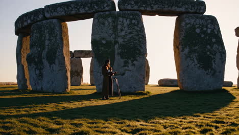 woman reading at stonehenge sunrise