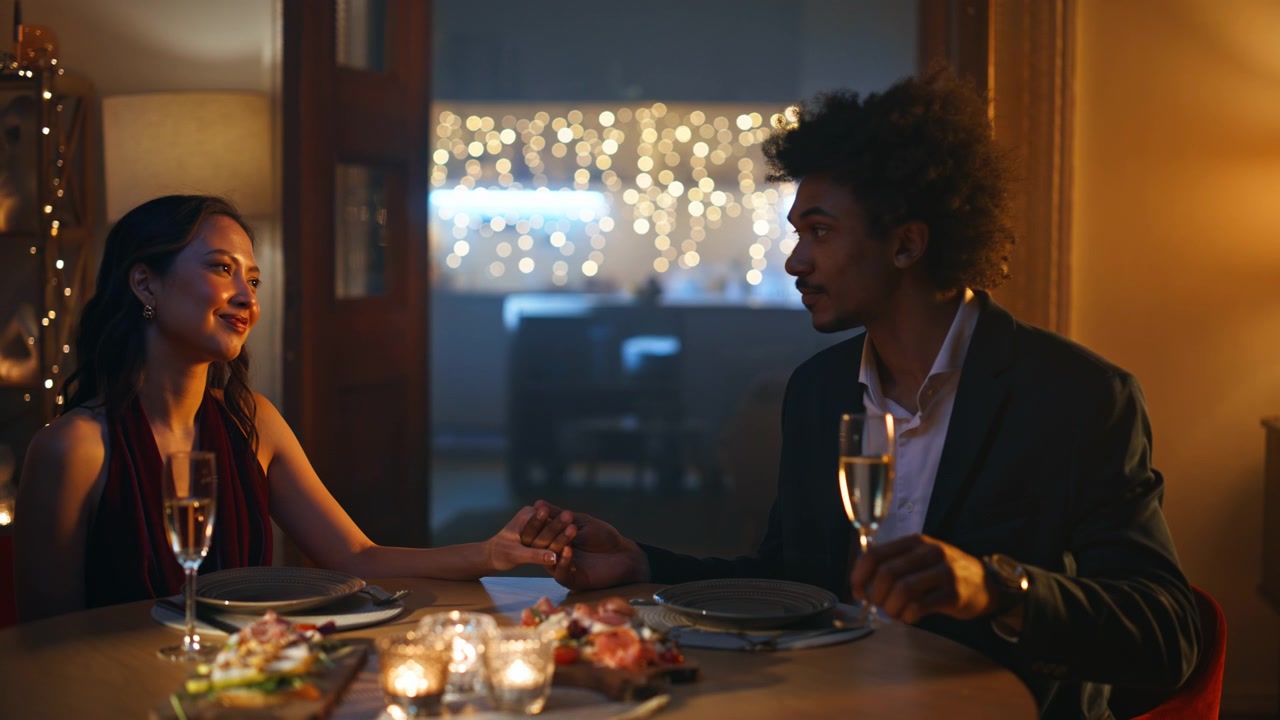 Cena romantica mano nella mano. Fidanzato che beve champagne a lume di candela
