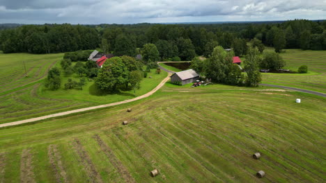 rural scene of agricultural land and farmhouses during harvest season. aerial drone shot