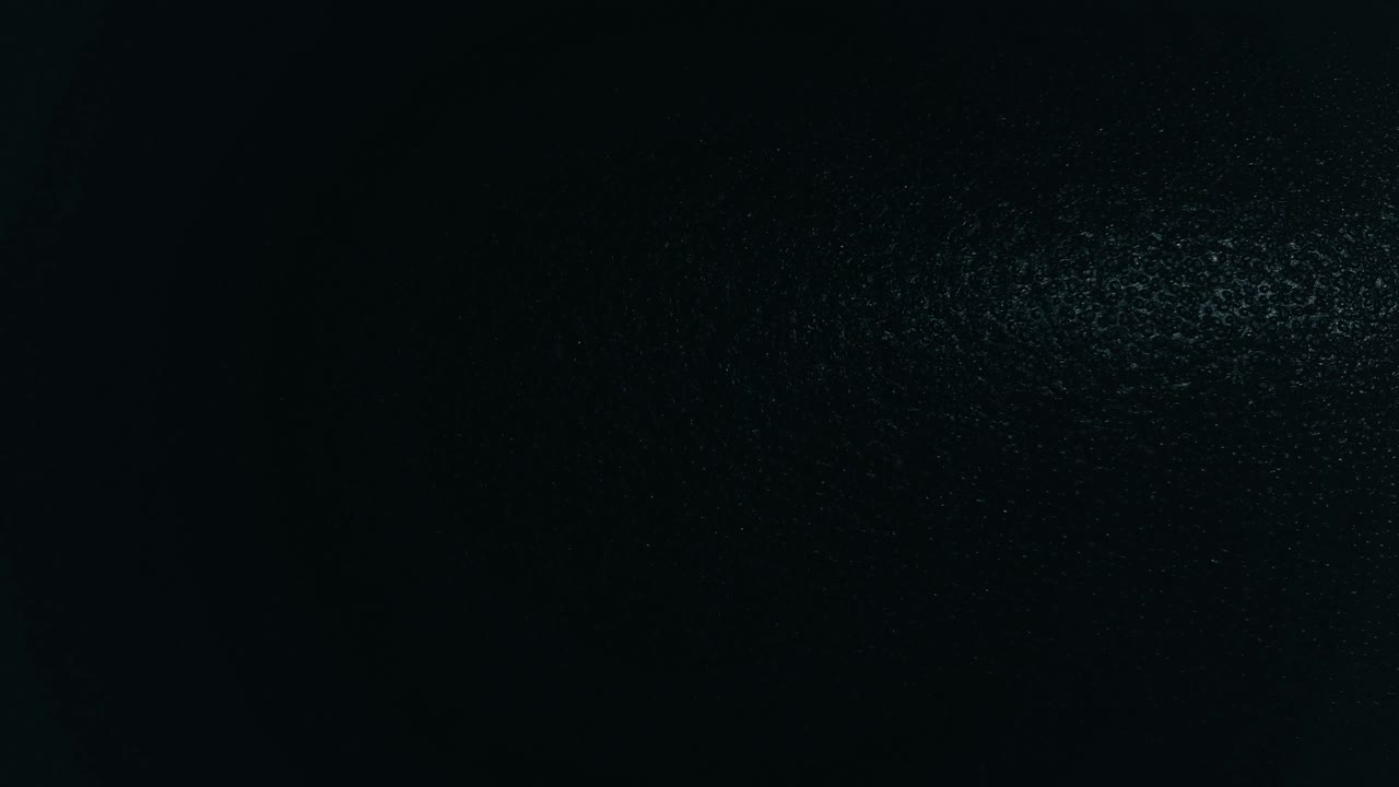 Light spot moving horizontally over dark black structured background pattern
