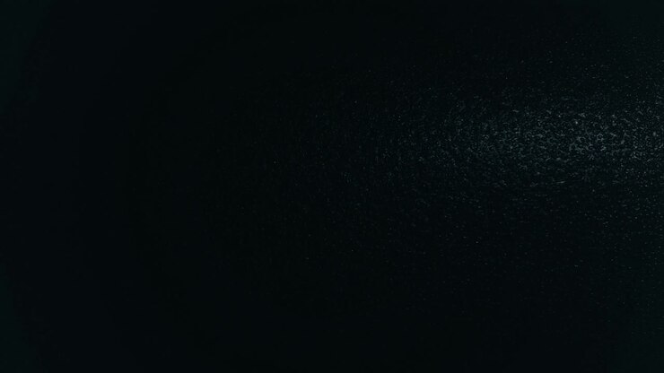 Light spot moving horizontally over dark black structured background pattern