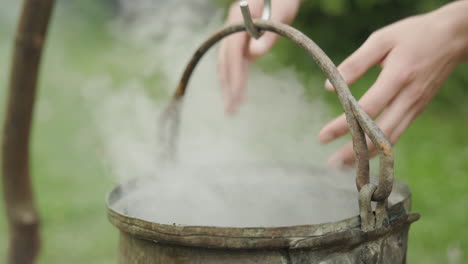 witch kettle steaming over fire, waving hands with magical spell, slow motion