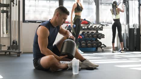 man taking protein shake in gym