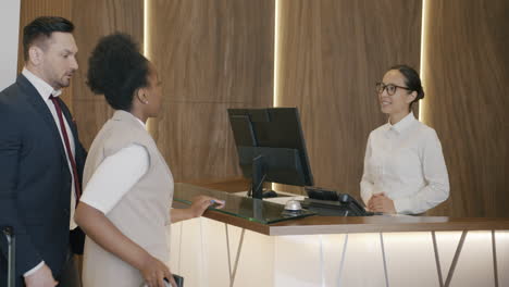pareja registrándose en la recepción del hotel