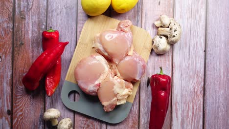 raw chicken thighs with red peppers, lemons, and mushrooms