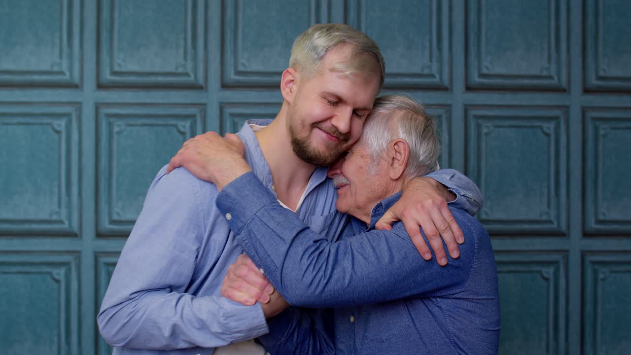 Uomo anziano e giovane uomo felici che si abbracciano.