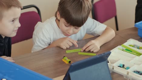 children engage in stem learning activities, assembling robotics kits with focus and teamwork in a classroom setting