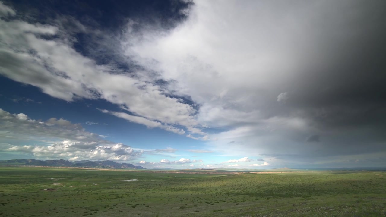 Time-lapse di nuvole temporalesche che si muovono su una vasta prateria verde.