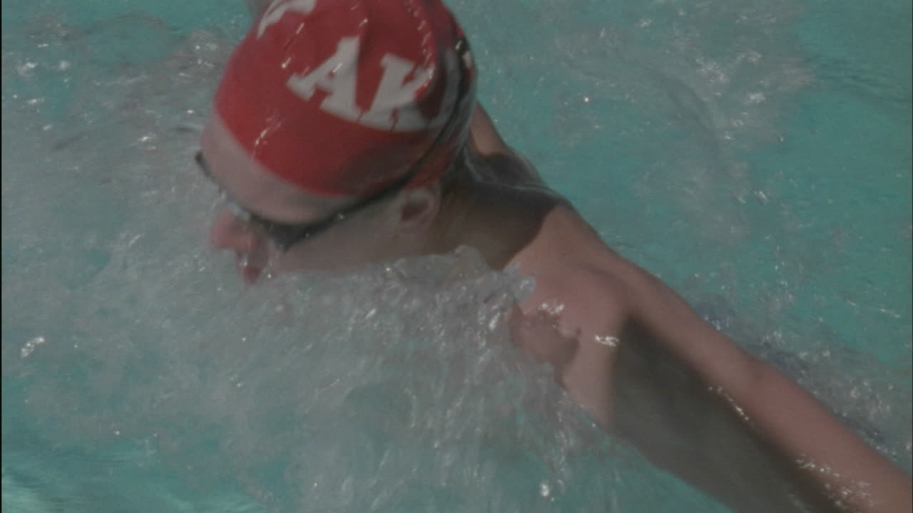 A woman swims across a pool turns and starts back