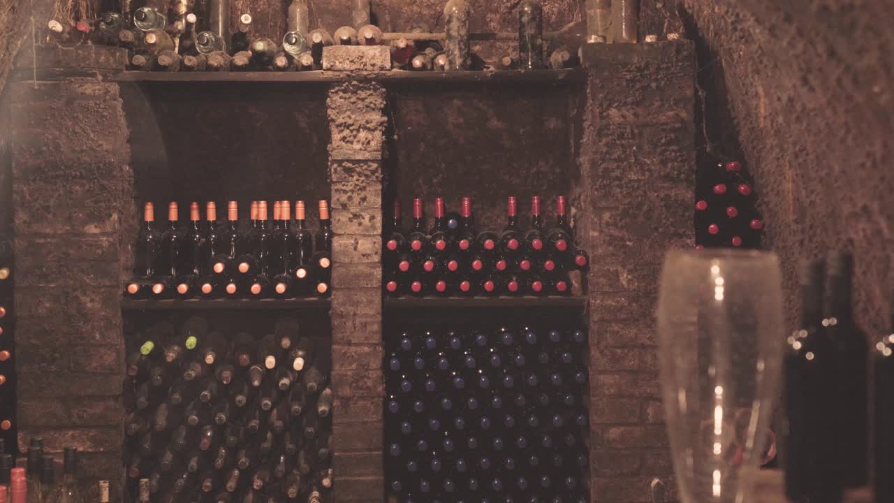 Antiga adega de vinhos com garrafas empilhadas nas prateleiras, estabelecimento
