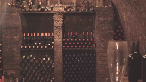 old wine cellar with wine bottles stacked on the shelves, establisher