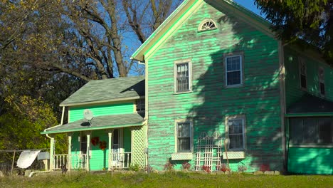 a weathered old green victorian house in the countryside