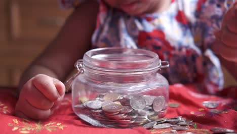 child saving money in a glass jar