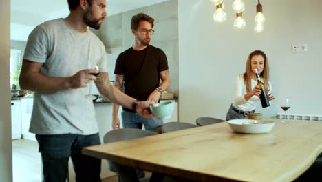 relaxed friends serving table for dinner together